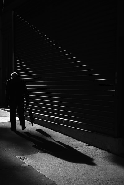 The man standing in front of the shutter grayscale images
